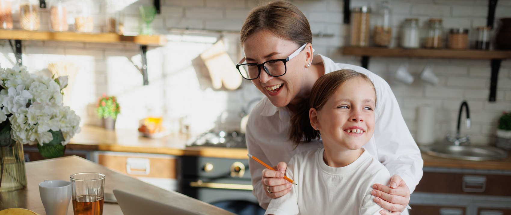 A mother and her daughter looking at the report together at the kitchen counter